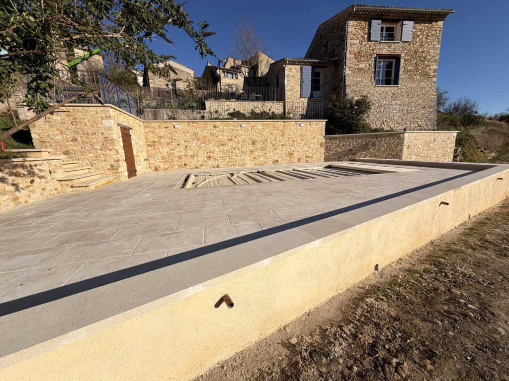 Plage de piscine avec local technique et escalier d'accès, murs et murets - CRT Forcalquier
