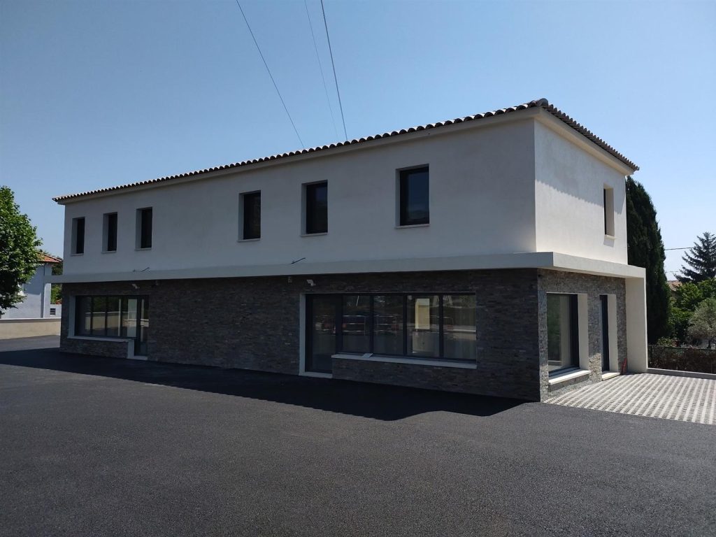 Facade du batiment tertiaire termine avec parement pierre - CRT Volx